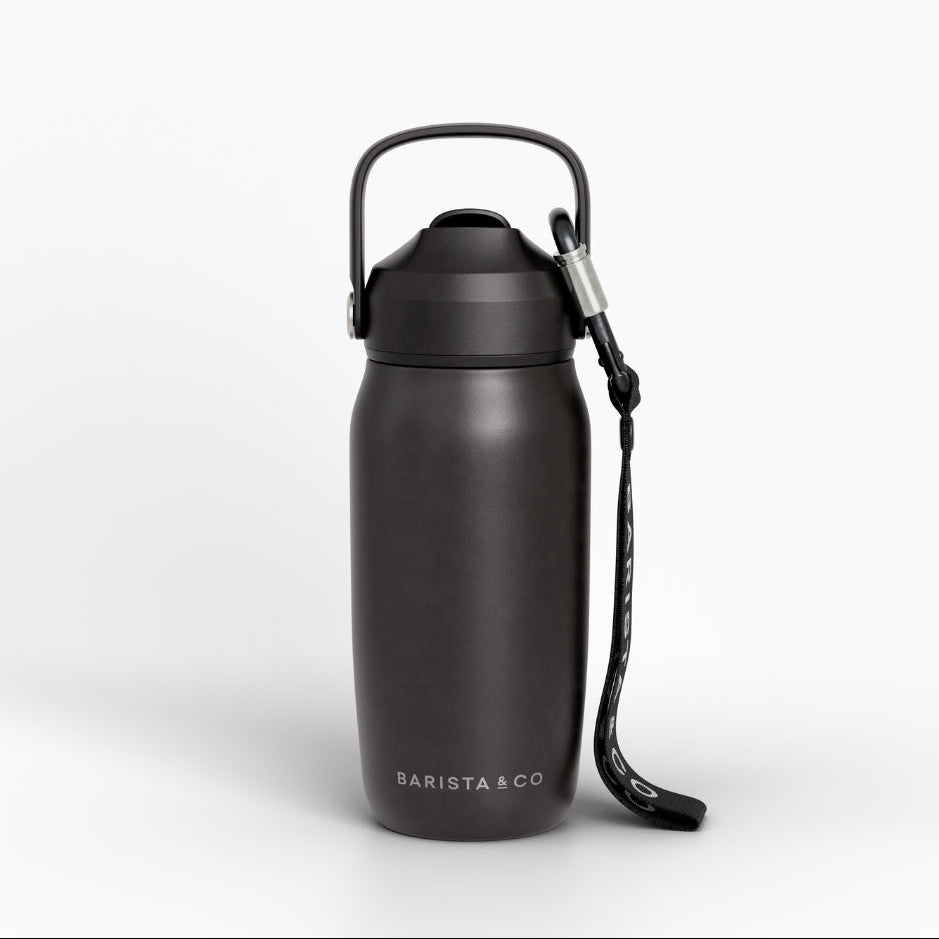 A matte black insulated water bottle with a carrying loop and wrist strap, featuring the BARISTA & CO logo near the base, set against a clean white background.