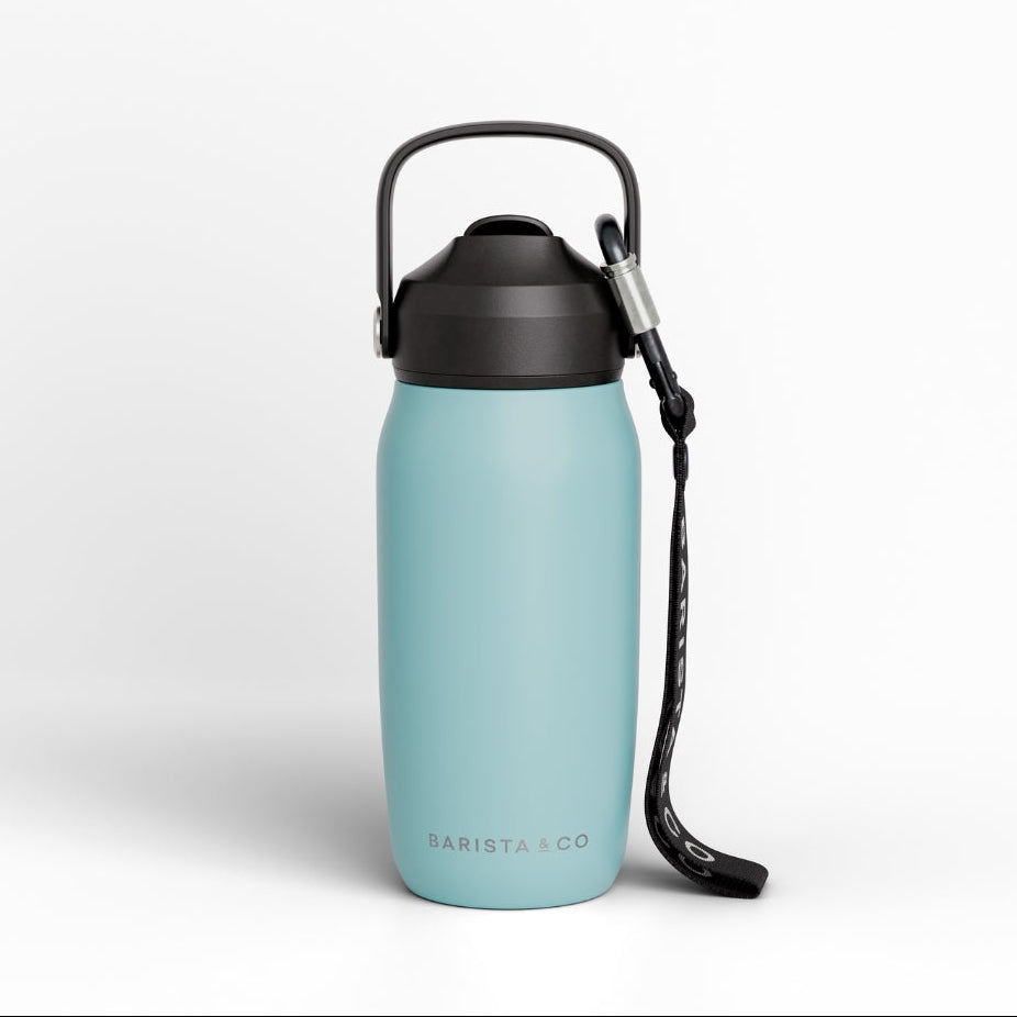 A light blue insulated water bottle with a black lid, carrying loop, and black wrist strap, shown on a clean white background. The brand name 'BARISTA CO' is printed near the bottom.