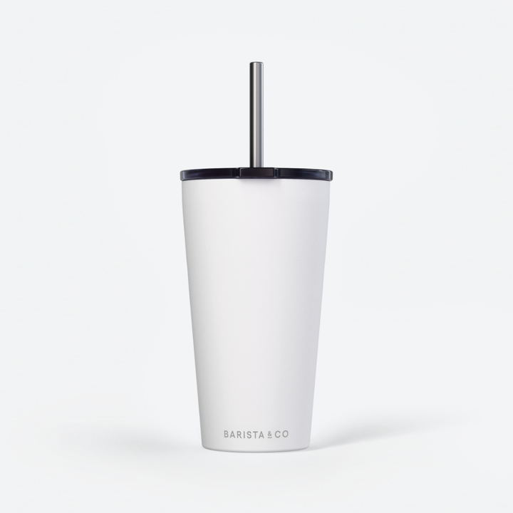 A white insulated travel tumbler with a black lid and a silver metal straw, featuring the BARISTA & CO logo near the bottom, set against a clean white background.
