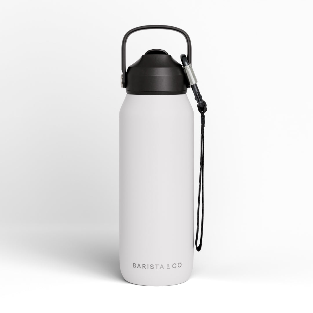 A white insulated water bottle with a black lid, carrying loop, and black wrist strap, shown on a clean white background. The brand name 'BARISTA CO' is printed near the bottom.