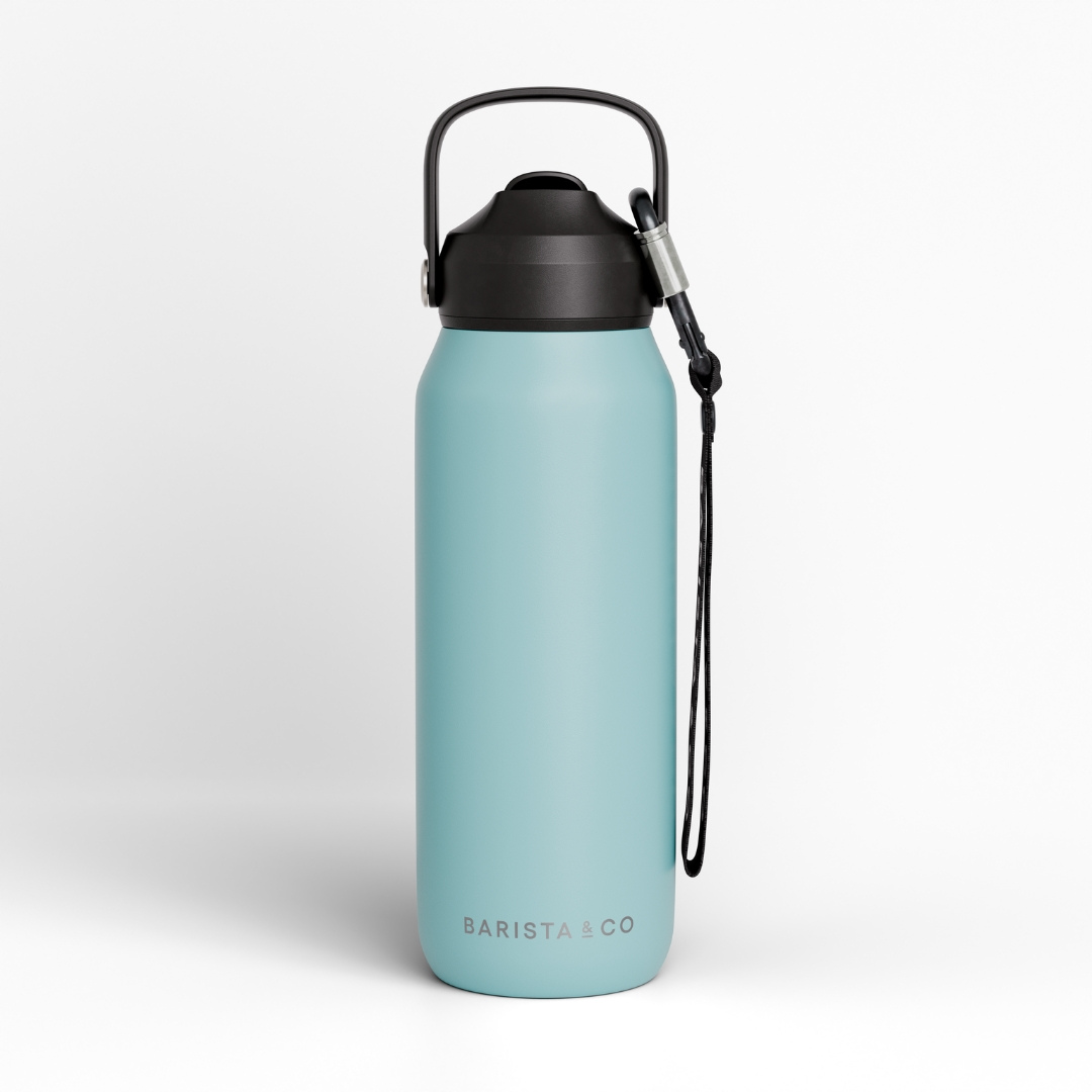A matte light blue insulated water bottle with a black screw cap, black carry loop, and black wrist strap, shown on a clean light gray background. The brand name 'BARISTA CO' is printed near the bottom.